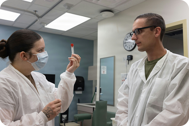 Researchers in a laboratory reviewing a sample vial